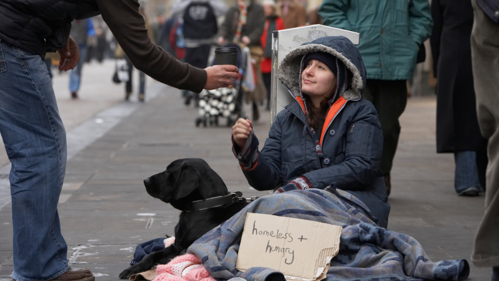 Homen dando agua para moradora de rua